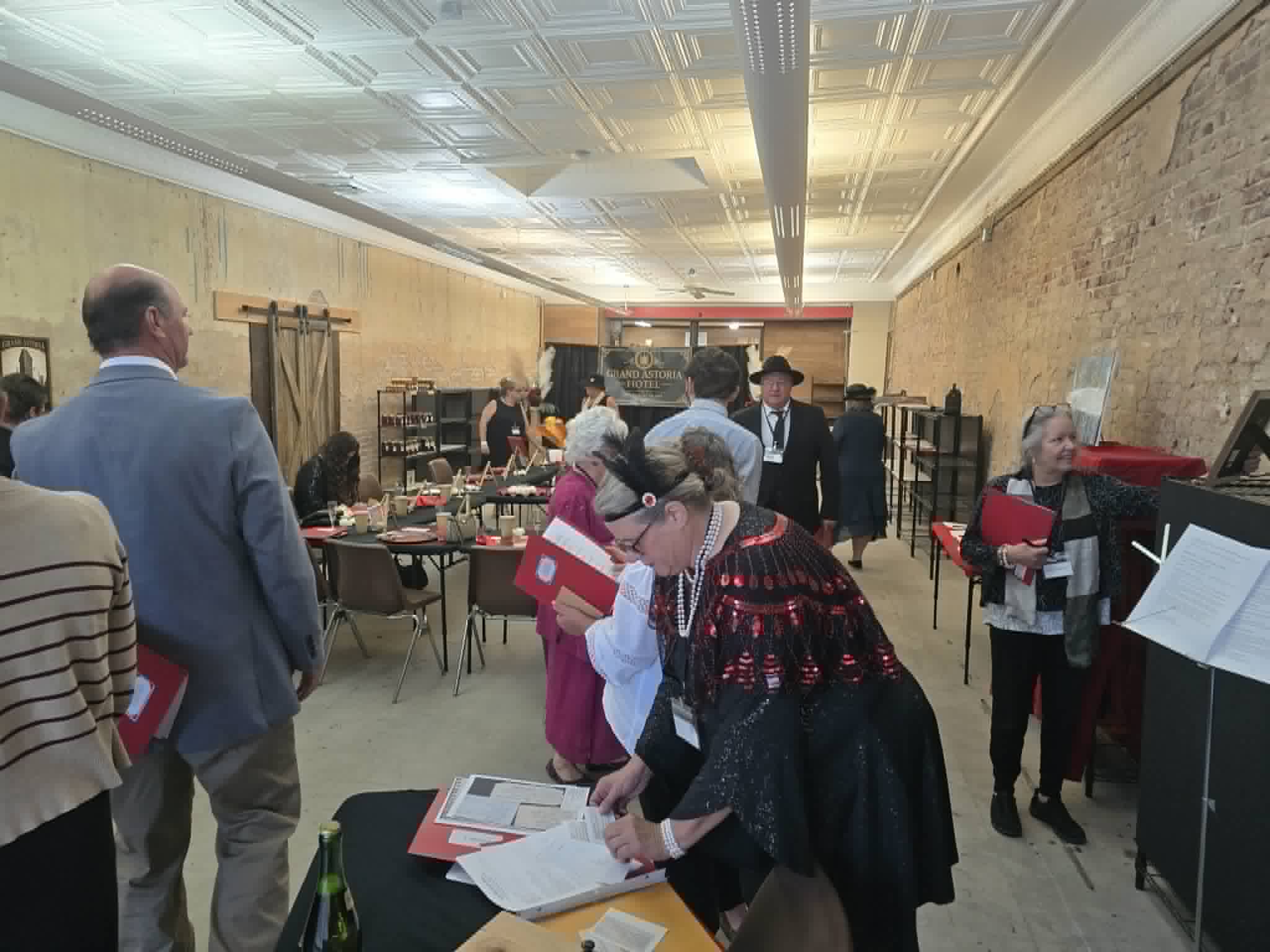 Guests in costume examining clue packets at a table during the mystery.