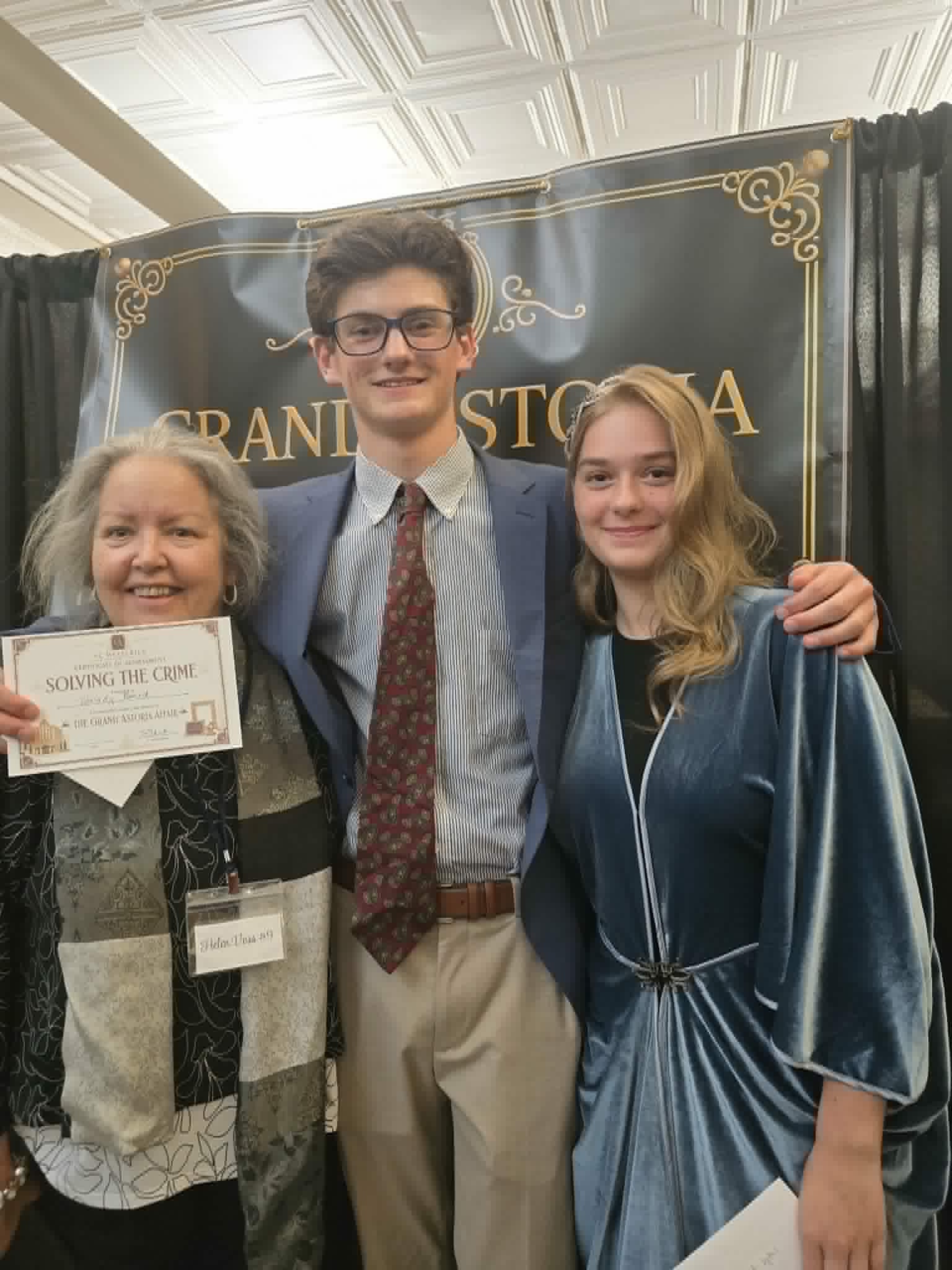Three guests holding a Solving the Crime certificate after The Grand Astoria Affair.